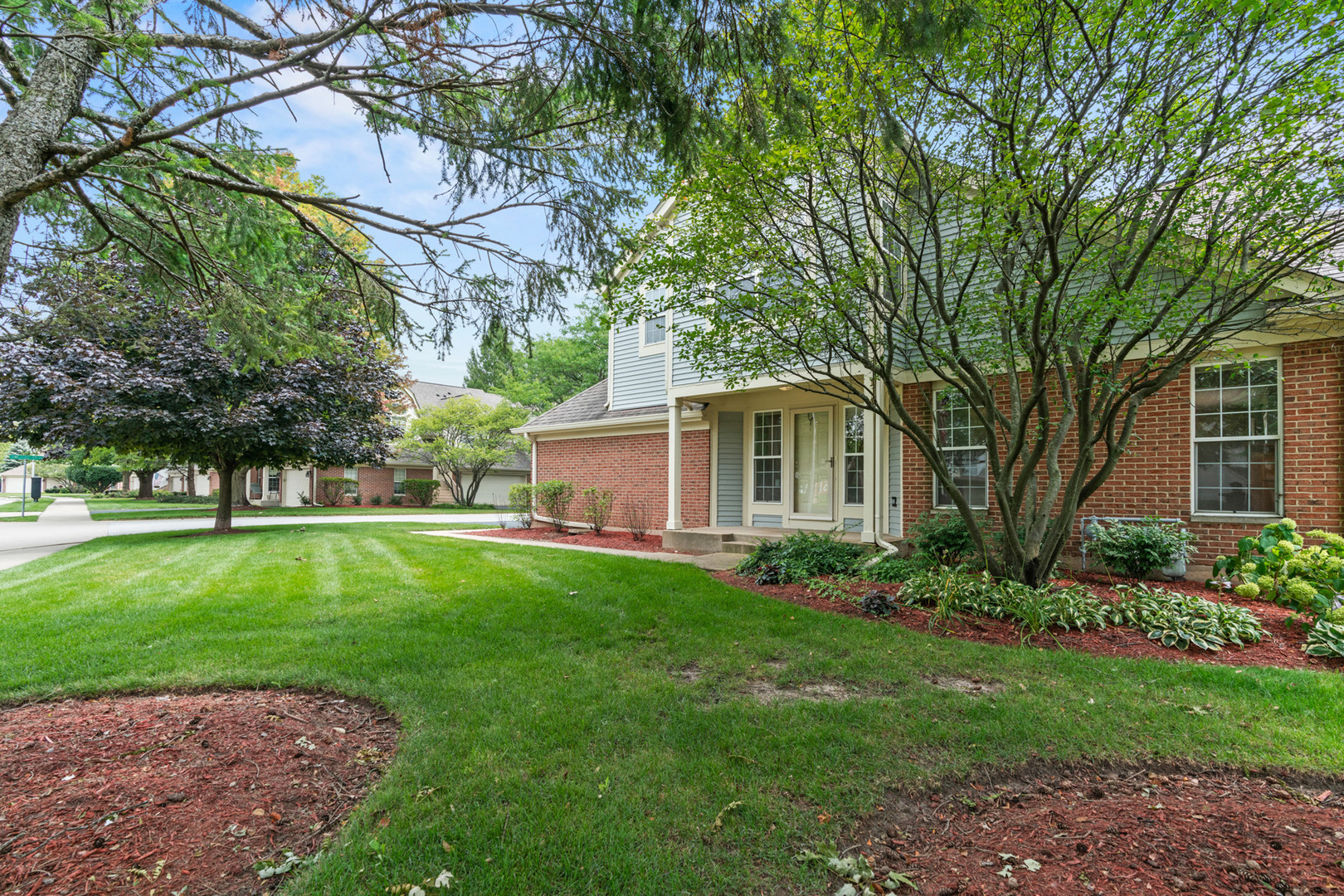 115 Ione Drive, Unit E South Elgin, IL 60177 - Photo 25 of 29 a front view of a house with a garden