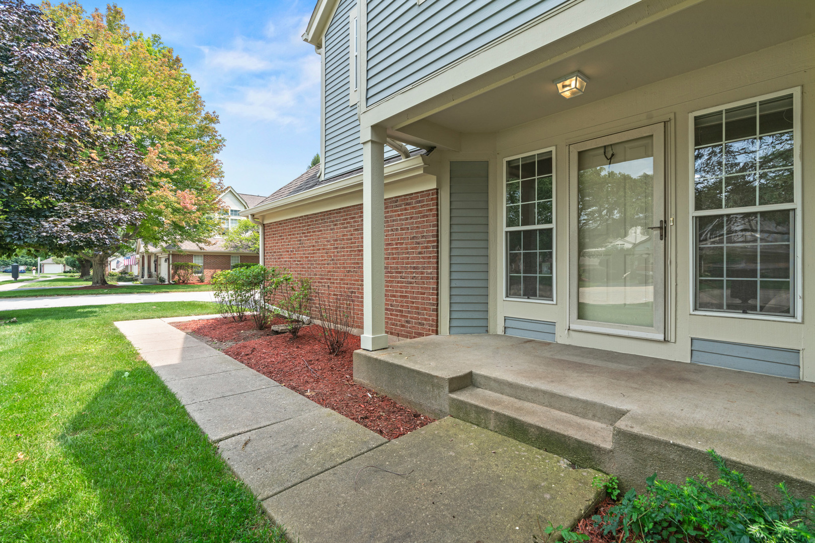 115 Ione Drive, Unit E South Elgin, IL 60177 - Photo 26 of 29 a front view of a house with a yard and garage