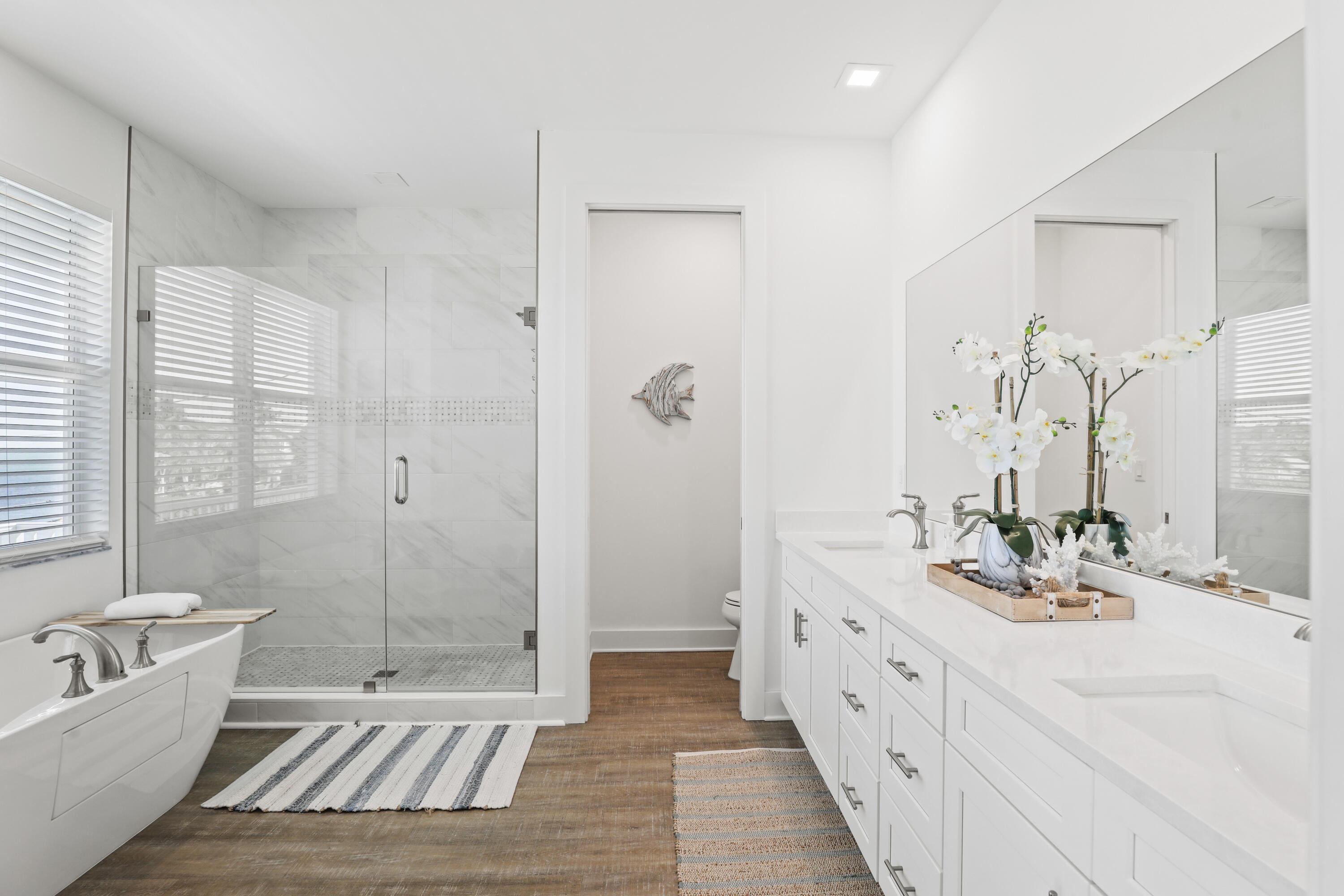 1140 92nd Street Marathon, FL 33050 - Photo 12 of 32 a spacious bathroom with a double vanity sink a large mirror a bathtub and shower