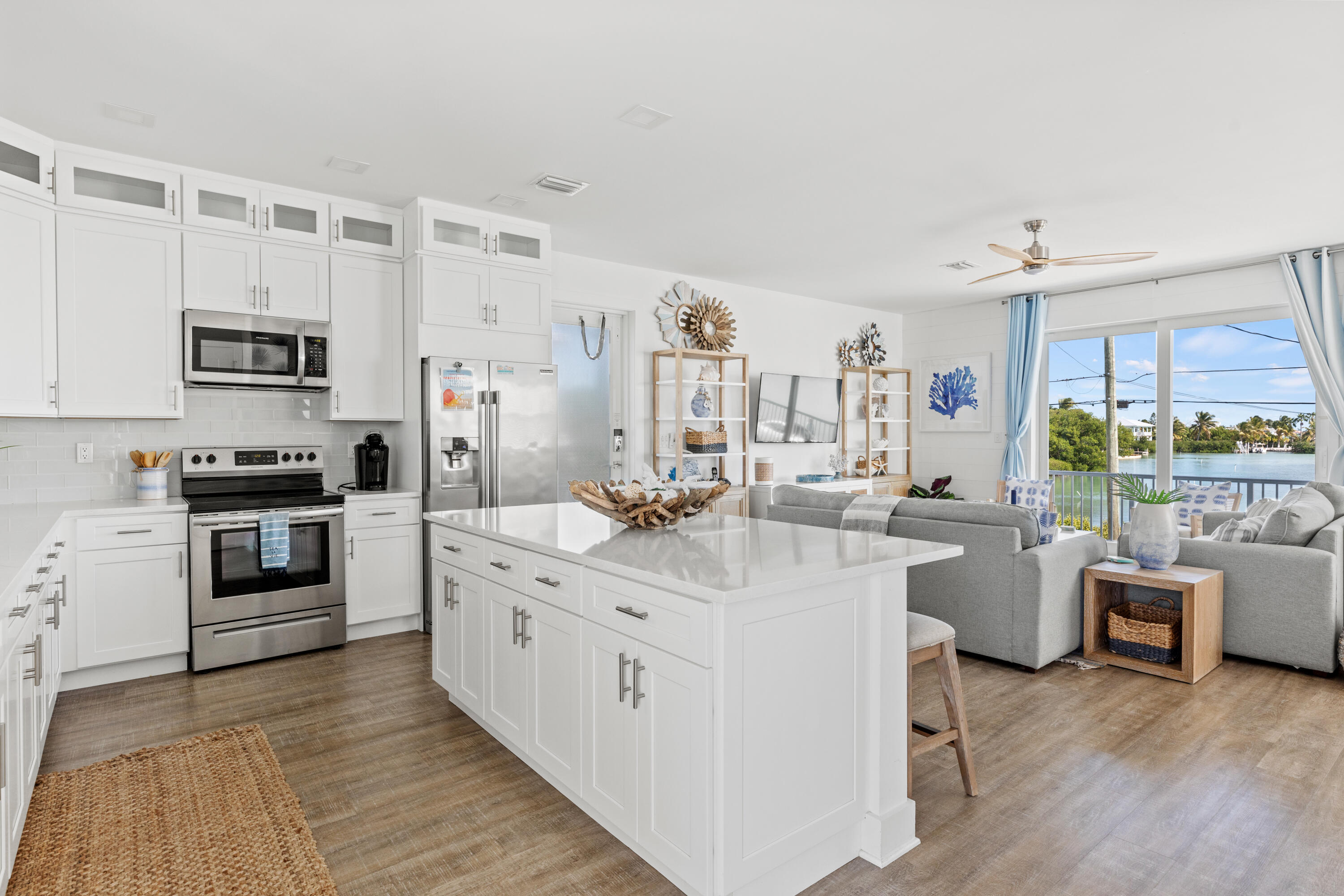 1140 92nd Street Marathon, FL 33050 - Photo 7 of 32 a kitchen with stainless steel appliances a stove a sink dishwasher a refrigerator and a dining table with wooden floor