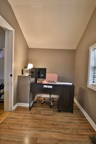 a view of a workspace with furniture and a window