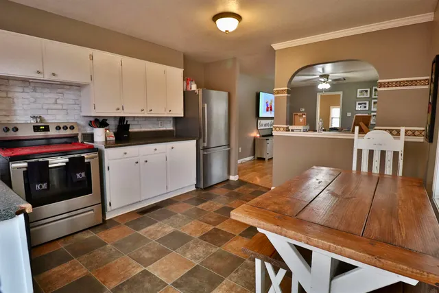 a kitchen with stainless steel appliances granite countertop a stove a sink and a refrigerator