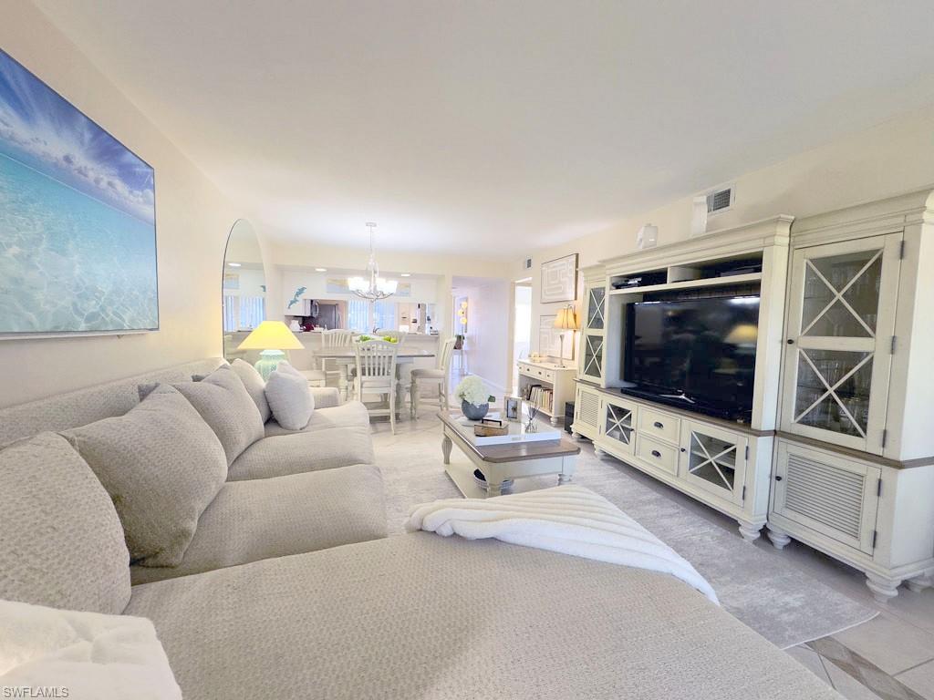 4085 Northlight Drive, Unit 5607 Naples, FL 34112 - Photo 25 of 49 a living room with furniture and a flat screen tv