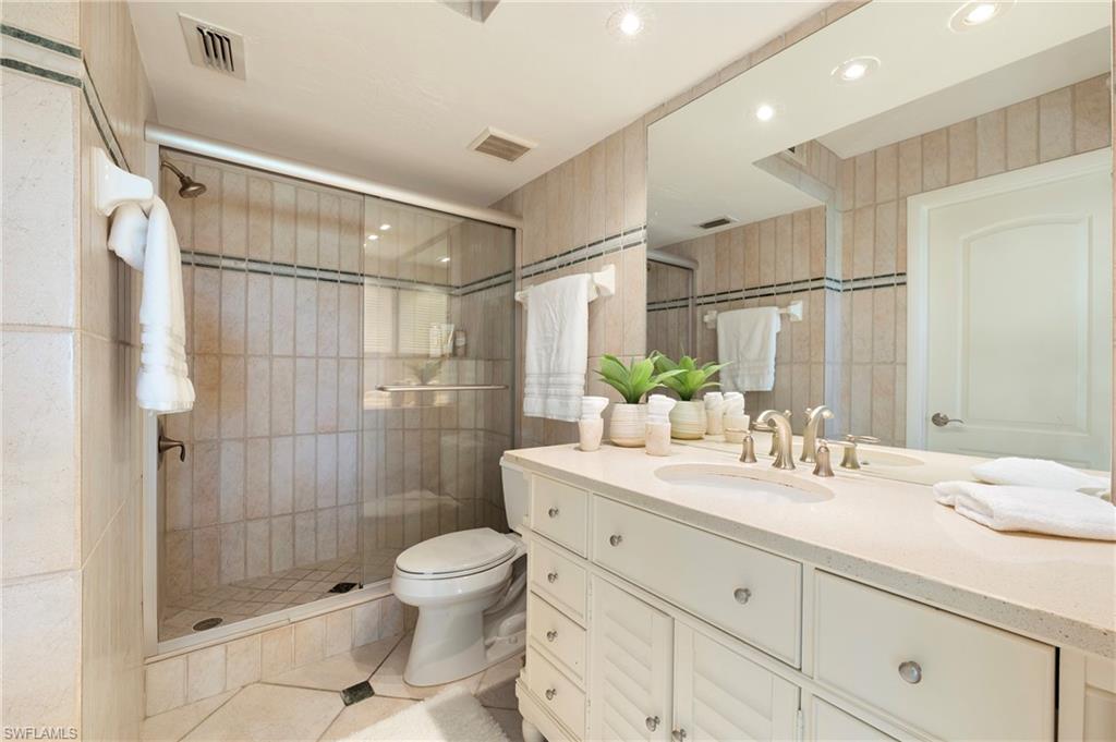 4085 Northlight Drive, Unit 5607 Naples, FL 34112 - Photo 29 of 49 a bathroom with a shower sink vanity mirror and toilet