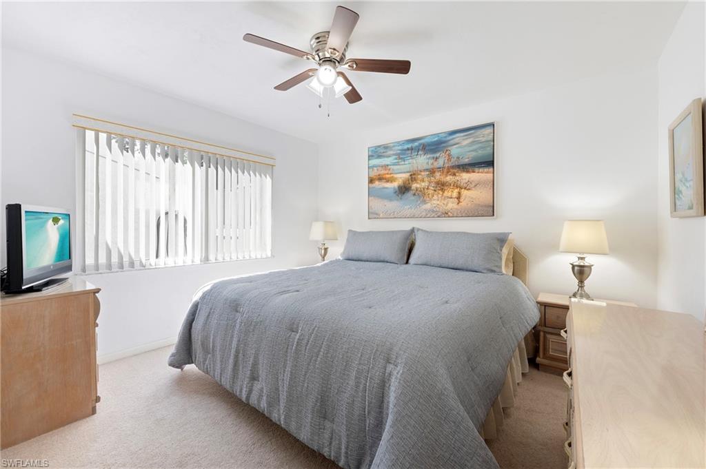 4085 Northlight Drive, Unit 5607 Naples, FL 34112 - Photo 33 of 49 a bedroom with a large bed and a chandelier