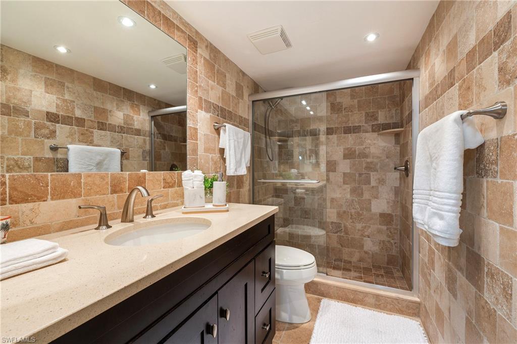 4085 Northlight Drive, Unit 5607 Naples, FL 34112 - Photo 34 of 49 a bathroom with a double vanity sink toilet and shower