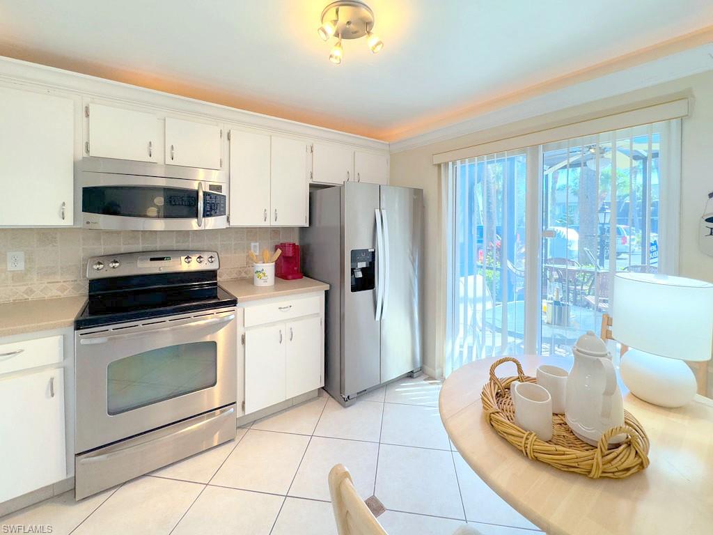 4085 Northlight Drive, Unit 5607 Naples, FL 34112 - Photo 36 of 49 a kitchen with a stove a sink and a microwave