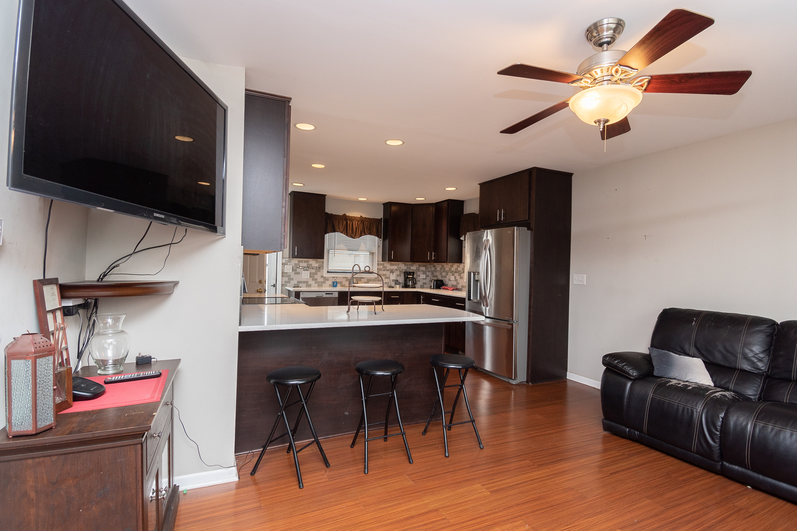 2106 20th Street Zion, IL 60099 - Photo 4 of 22 a living room with stainless steel appliances kitchen island granite countertop furniture and a flat screen tv