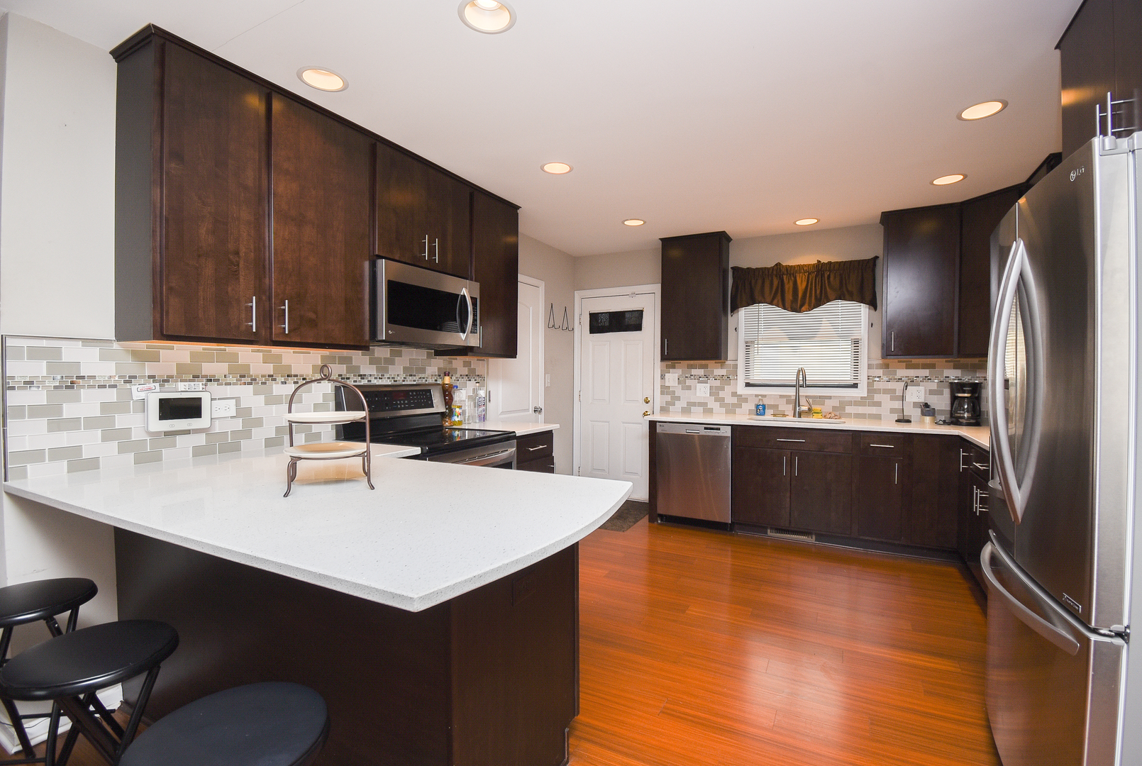 2106 20th Street Zion, IL 60099 - Photo 7 of 22 a kitchen with a sink cabinets and wooden floor