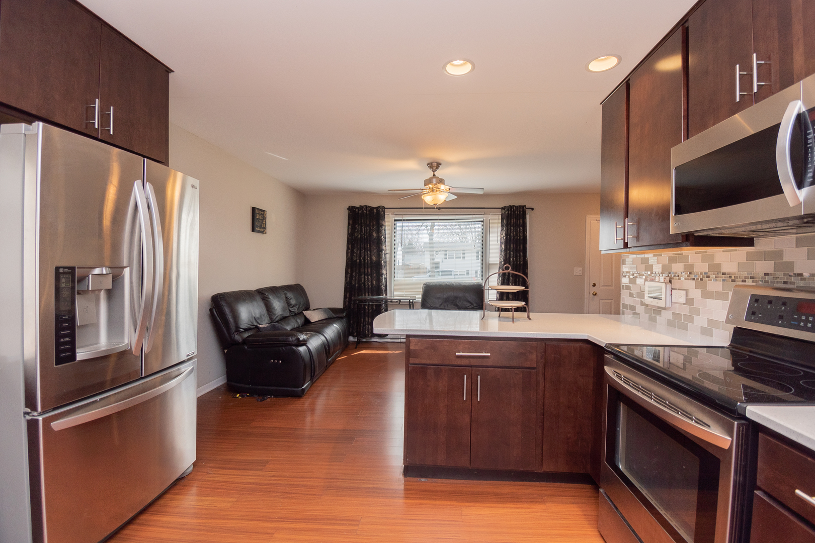 2106 20th Street Zion, IL 60099 - Photo 9 of 22 a kitchen with stainless steel appliances granite countertop a refrigerator a sink dishwasher a stove and white countertops with wooden floor