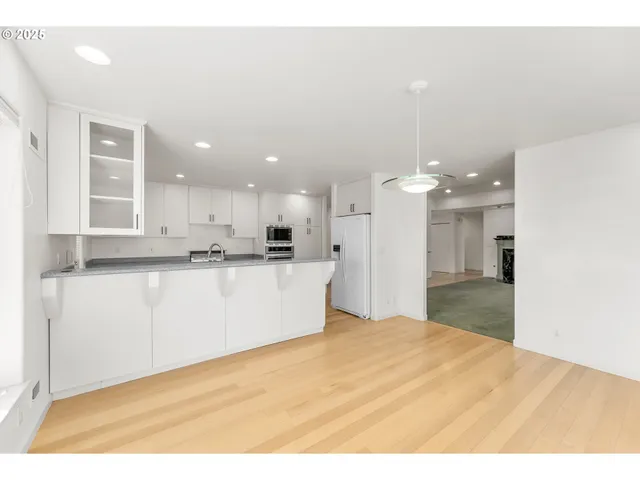 a view of a kitchen with kitchen island a sink stainless steel appliances and cabinets