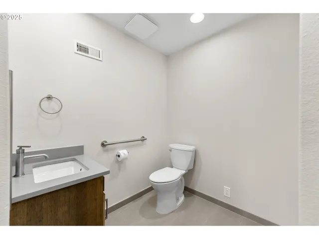 a bathroom with a toilet a sink and mirror