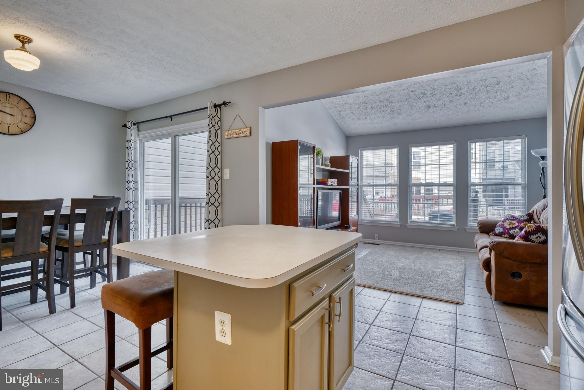 5030 Finsbury Road Rosedale, MD 21237 - Photo 24 of 49 a kitchen with stainless steel appliances kitchen island granite countertop a table chairs and a large window