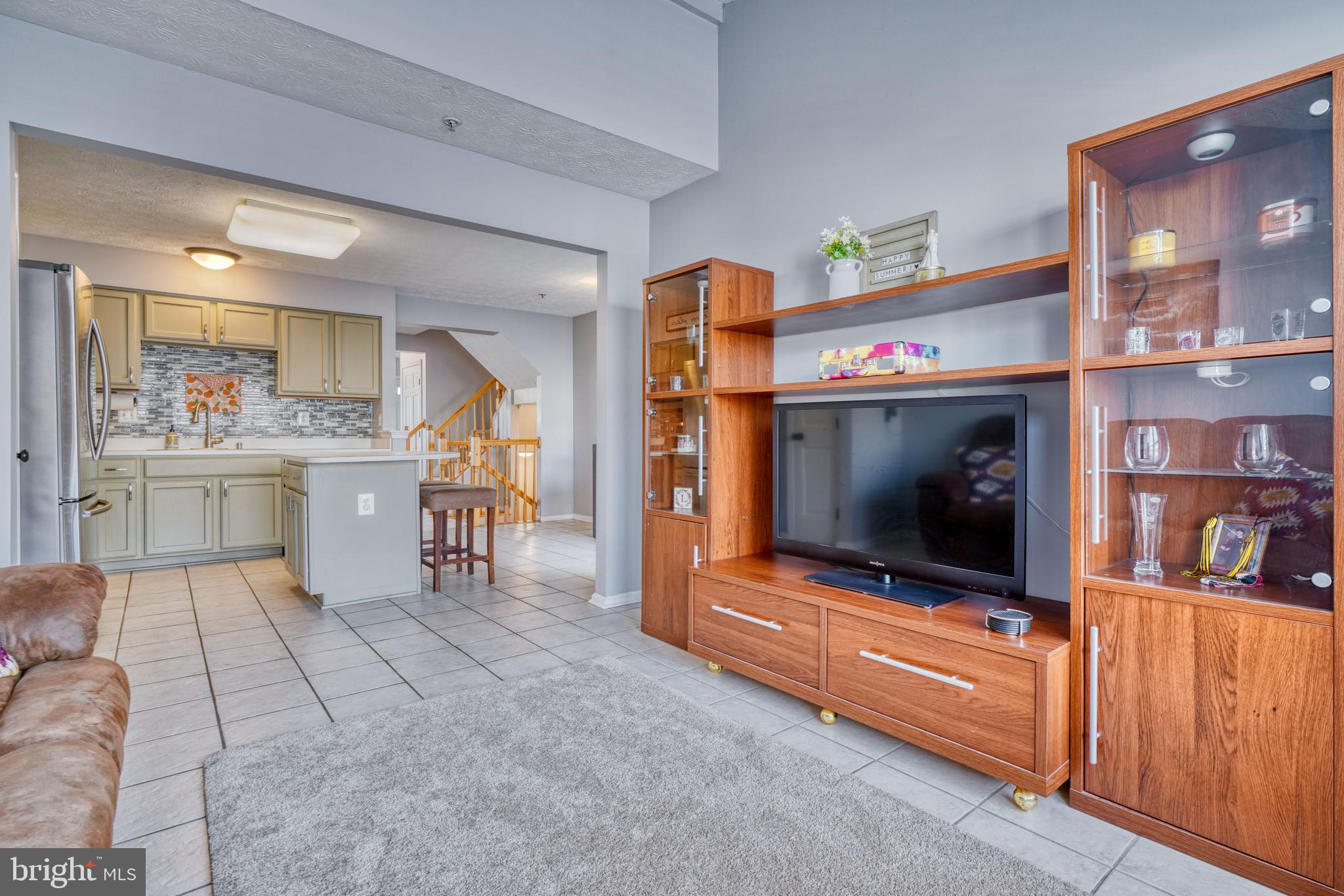 5030 Finsbury Road Rosedale, MD 21237 - Photo 27 of 49 a living room with furniture a flat screen tv and a kitchen area