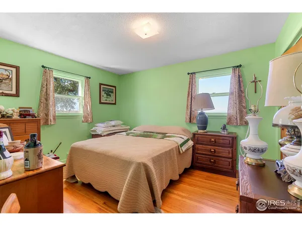 a bedroom with a bed and a lamp on dresser