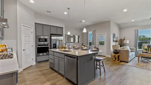 a kitchen that has a lot of cabinets a sink and appliances