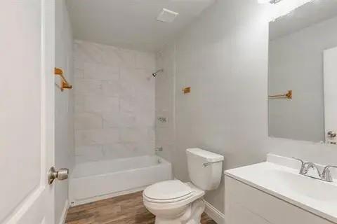 221 Braz Street Bonham, TX 75418 - Photo 11 of 12 Bathroom featuring vanity, bathtub / shower combination, and wood finished floors