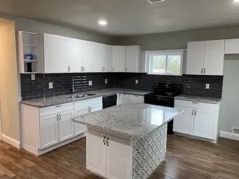 221 Braz Street Bonham, TX 75418 - Photo 4 of 12 Kitchen with light stone counters, dark wood-type flooring, white cabinetry, and recessed lighting