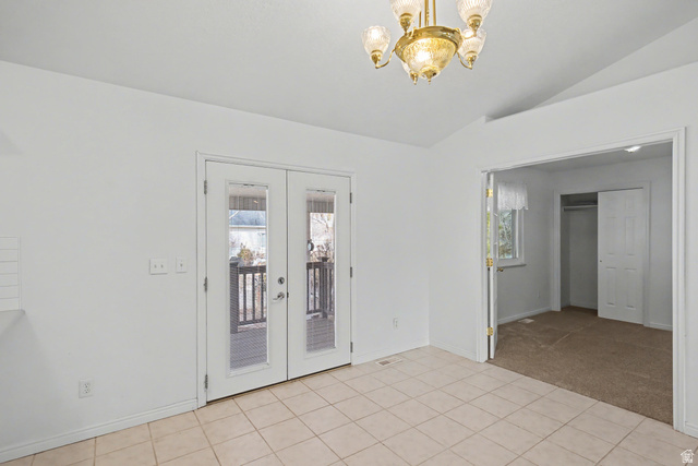 281 Winchester Drive Springville, UT 84663 - Photo 17 of 27 Empty room with french doors, a chandelier, lofted ceiling, light carpet, and light tile patterned floors
