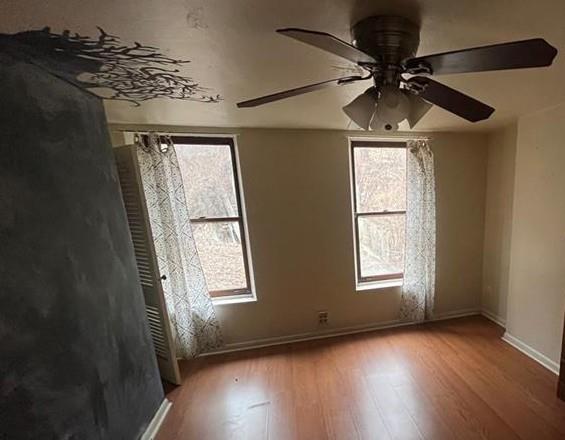 2918 Leander Street Pittsburgh, PA 15219 - Photo 8 of 9 an empty room with wooden floor fan and windows