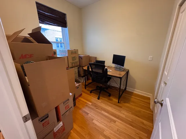 a view of a workspace with furniture and a window