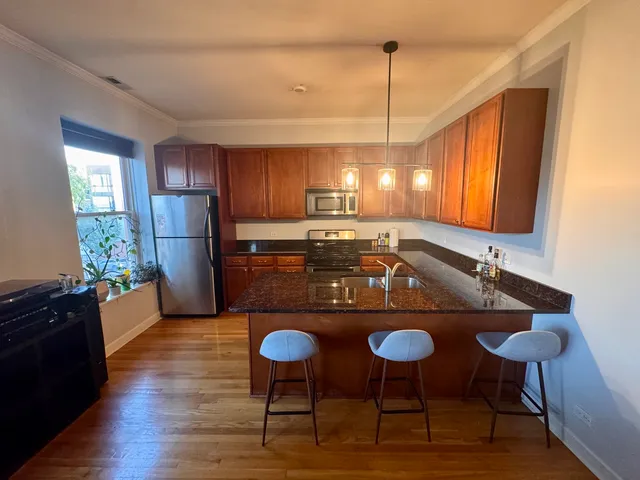 a kitchen with stainless steel appliances granite countertop a sink refrigerator and cabinets