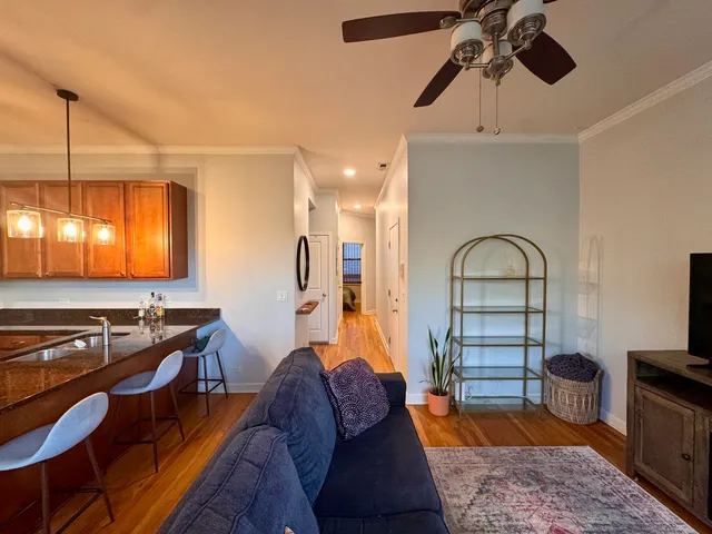 a living room with furniture a flat screen tv and kitchen view