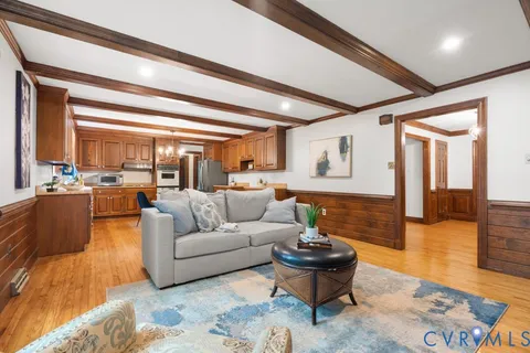 a living room with furniture and view of kitchen