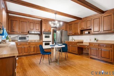 a kitchen with granite countertop wooden floors and wooden cabinets