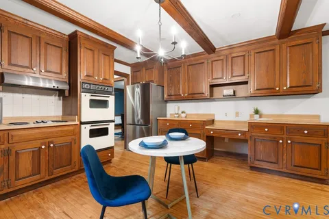 a kitchen with stainless steel appliances granite countertop a stove a sink dishwasher and cabinets with wooden floor