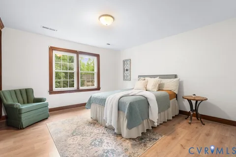 a spacious bedroom with a bed a couch and a window