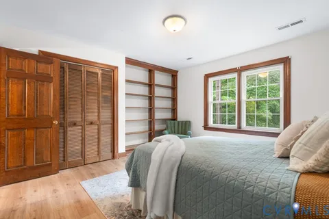 a spacious bedroom with a bed and a large window