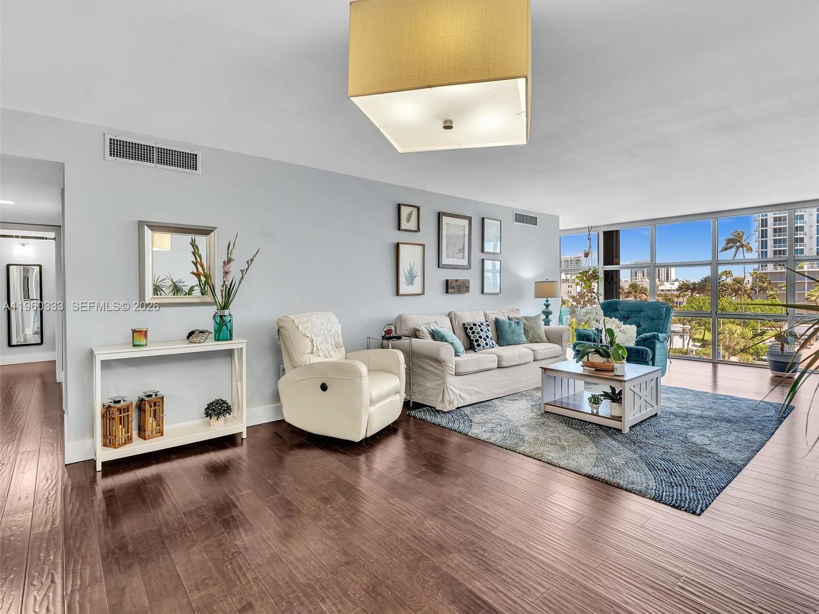 6423 Collins Avenue, Unit 409 Miami Beach, FL 33141 - Photo 13 of 61 a living room with furniture and a wooden floor