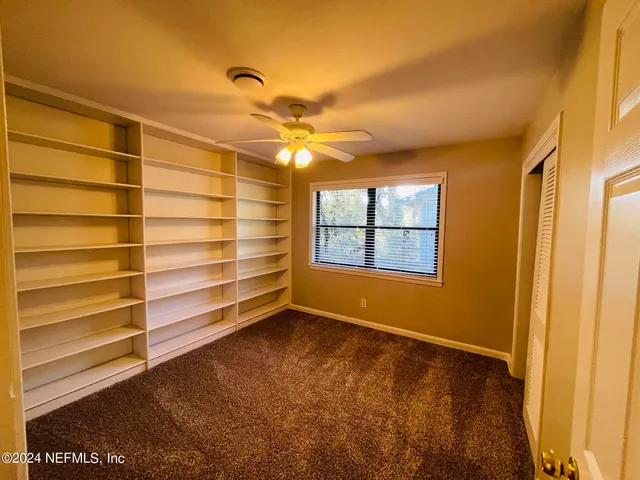 a view of room with a ceiling fan and wooden floor
