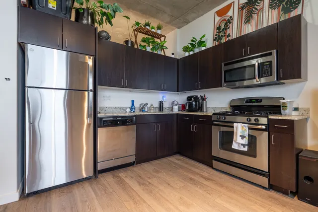 a kitchen with stainless steel appliances granite countertop a refrigerator and a stove top oven