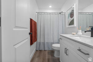 907 West Bright Ridge Ln Street, Unit 1430 St. George, UT 84790 - Photo 14 of 19 Bathroom featuring wood-finish flooring, a white vanity with a light-colored countertop, a sink with a matte black faucet, and a mirror