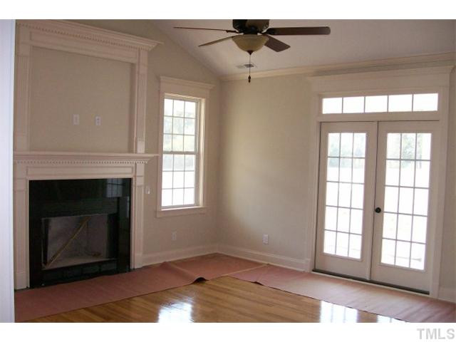 84 South Sunset Ridge Drive Willow Spring, NC 27592 - Photo 9 of 21 a view of an empty room with wooden floor and a fireplace