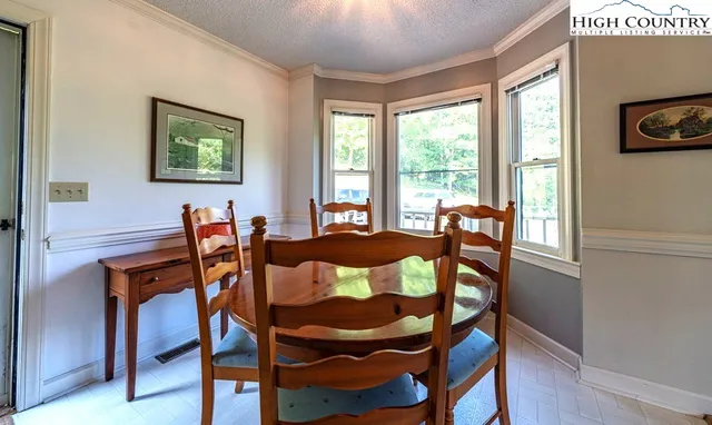 a view of a dining room with furniture a chandelier and wooden floor