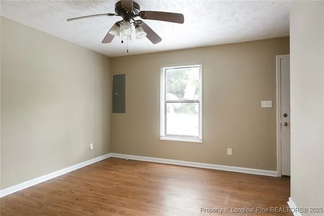 an empty room with a window and a chandelier fan