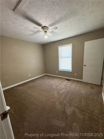 an empty room with a ceiling fan and window