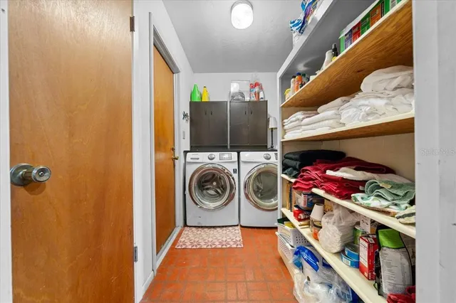 a kitchen with stainless steel appliances granite countertop a refrigerator a sink dishwasher a stove top oven a dining table and chairs with wooden floor