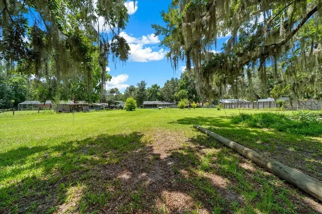 an aerial view of residential house with outdoor space and trees all around