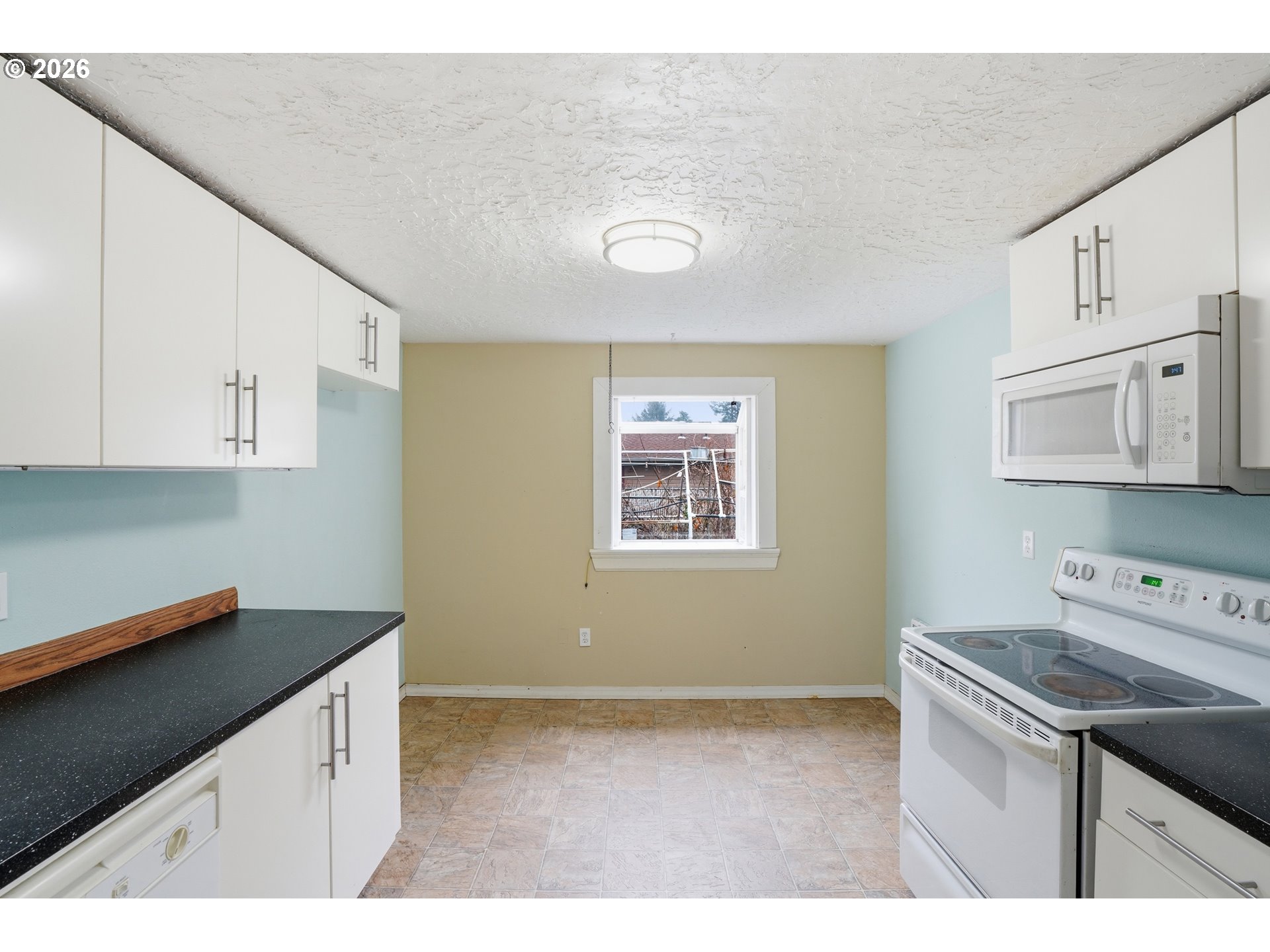 40 Southeast 133rd Avenue, Unit B Portland, OR 97233 - Photo 12 of 24 a kitchen with cabinets appliances and a window