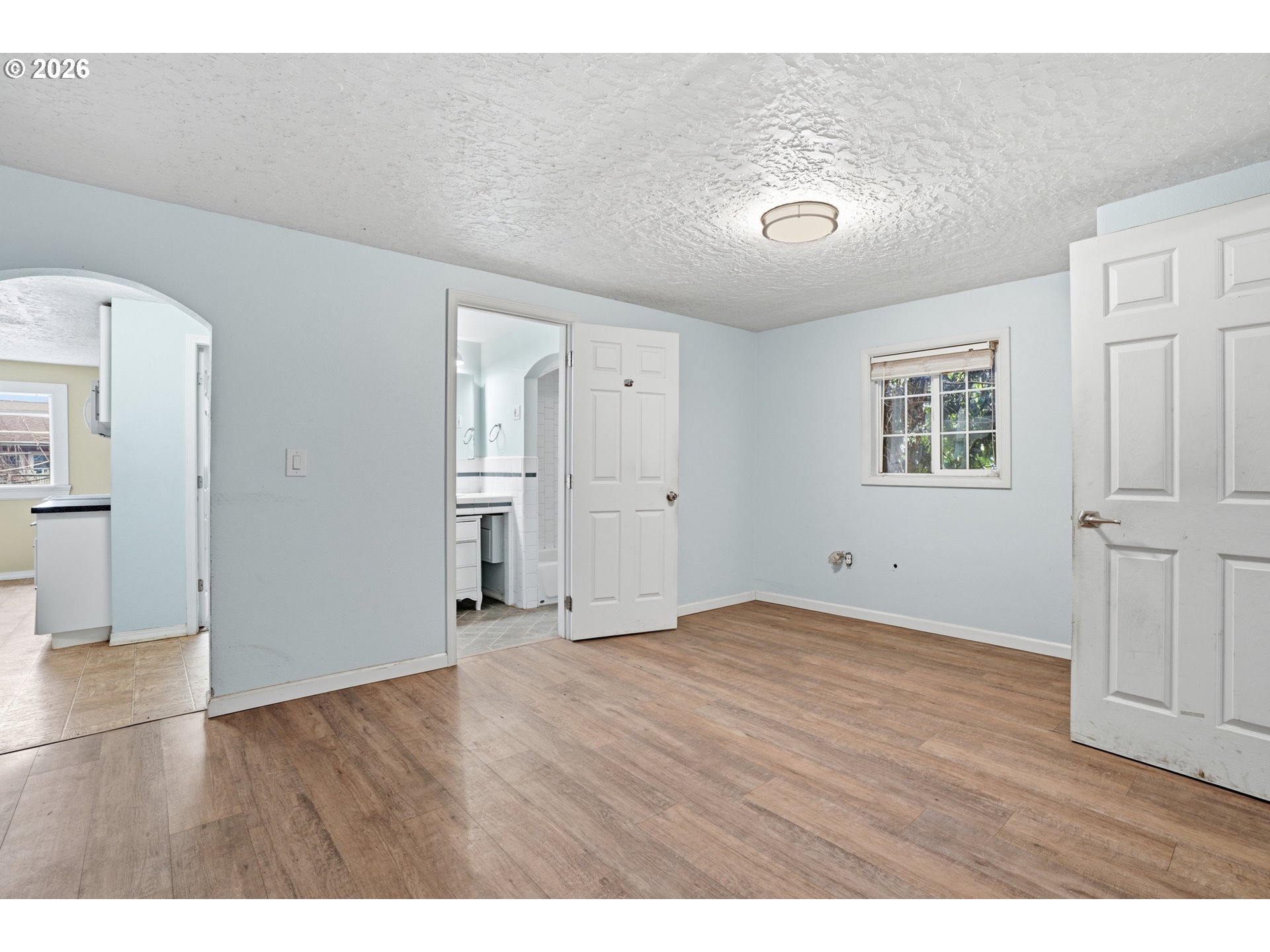 40 Southeast 133rd Avenue, Unit B Portland, OR 97233 - Photo 7 of 24 a view of an empty room with wooden floor and a window