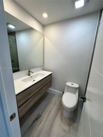 a bathroom with a sink mirror vanity and toilet