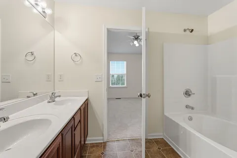 a bathroom with a tub sink and mirror