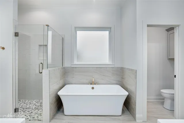 a white bath tub sitting next to a white toilet