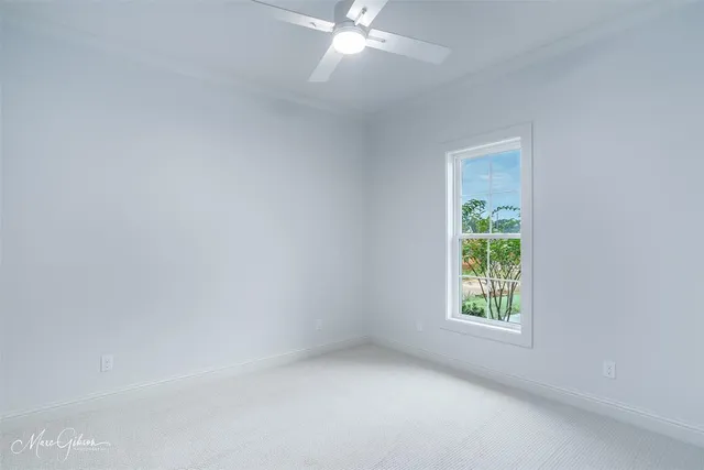 an empty room with a window and a fan