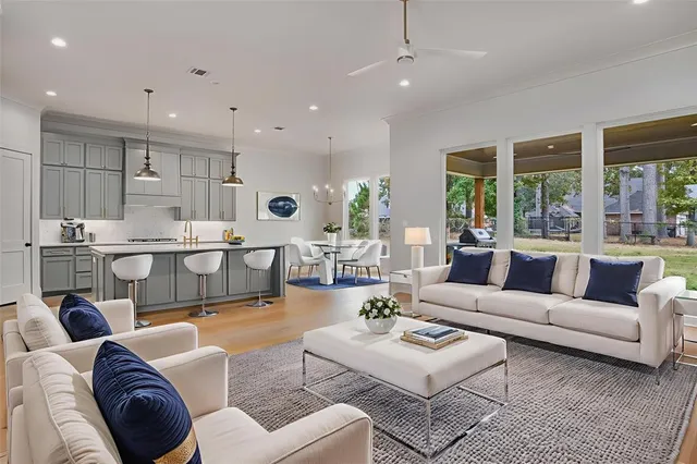 a living room with furniture kitchen view and a large window