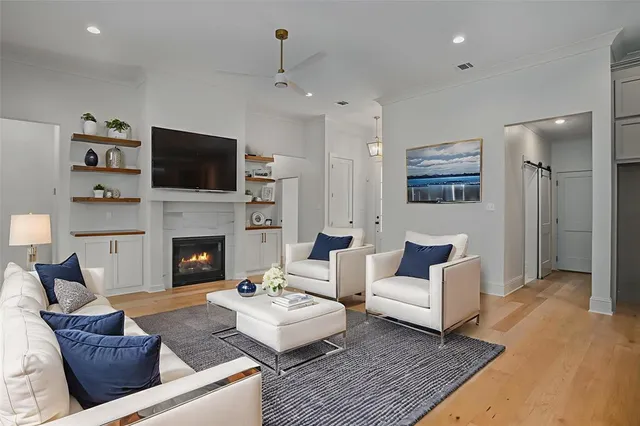a living room with furniture a flat screen tv and a fireplace
